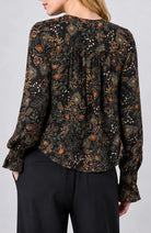 Back view of the Long Sleeve Woven Blouse with Pintucks in Black Rust floral, gathered back yoke with ruffled cuffs