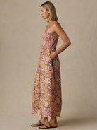 Woman wearing a floral dress against a beige background