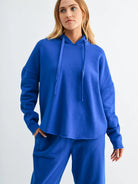 woman wearing bright blue hoodie and matching pants