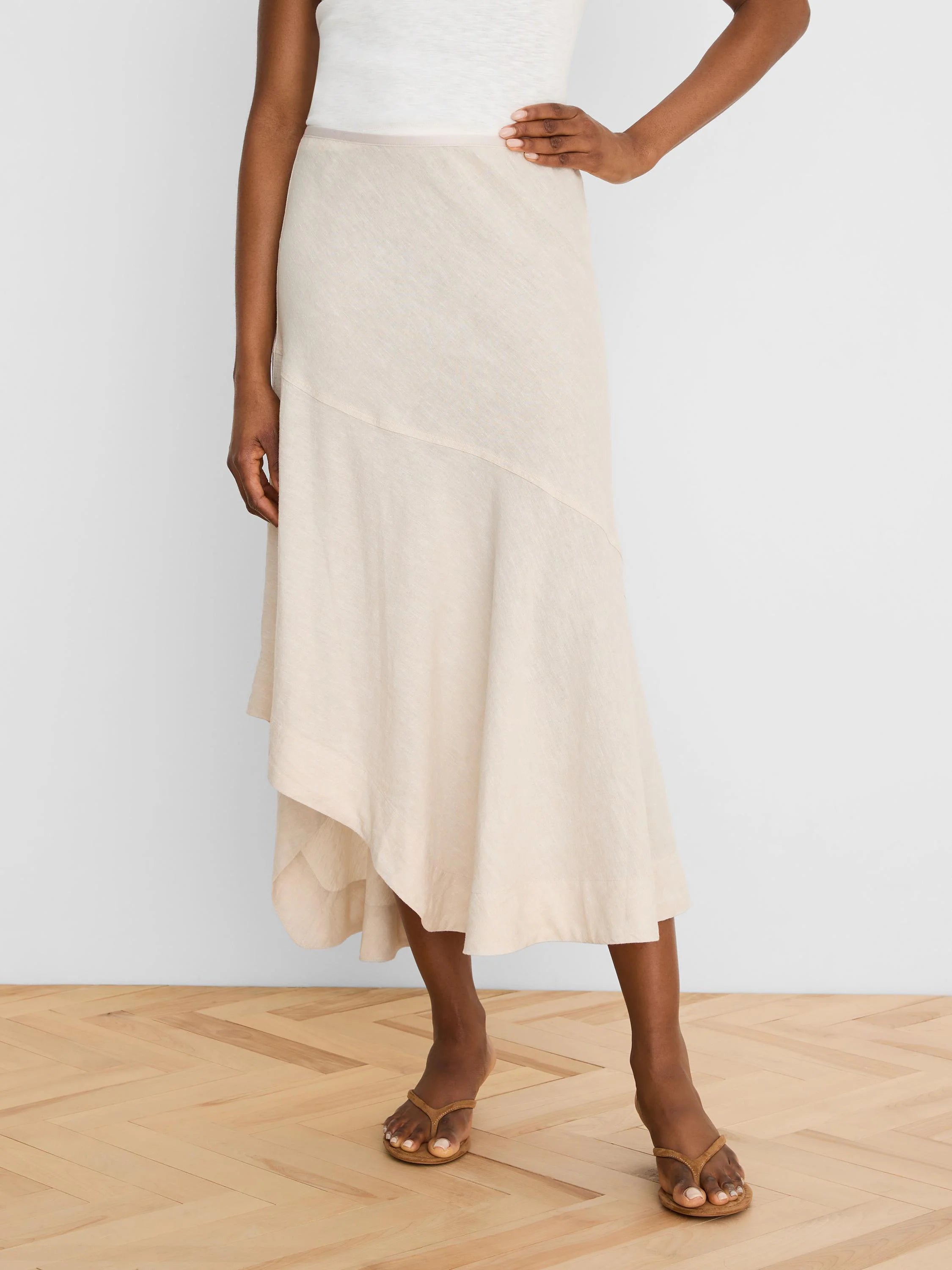 Person wearing a beige skirt on a plain background