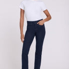 A woman modeling NYDJ Marilyn Straight jeans in Rinse dark blue wash, paired with a white t-shirt, against a plain light studio background.