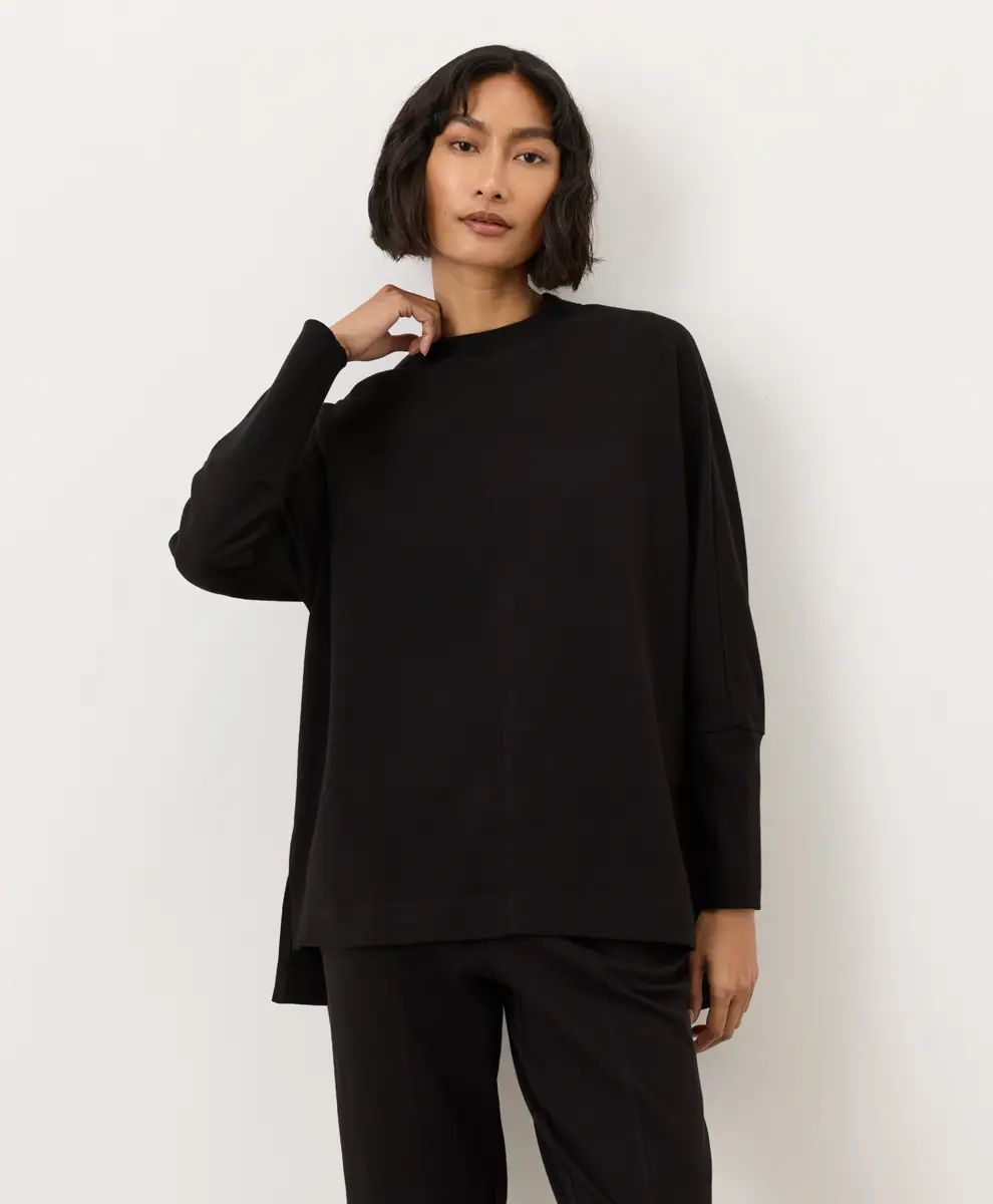 PACT Airplane Long Sleeve Poncho in black, front view, styled with matching black pants
