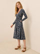 PACT Fit and Flare Wrap Dress in Mountain Meadow Midnight Blue navy floral print, long-sleeve wrap midi with tie waist and pocket, side view