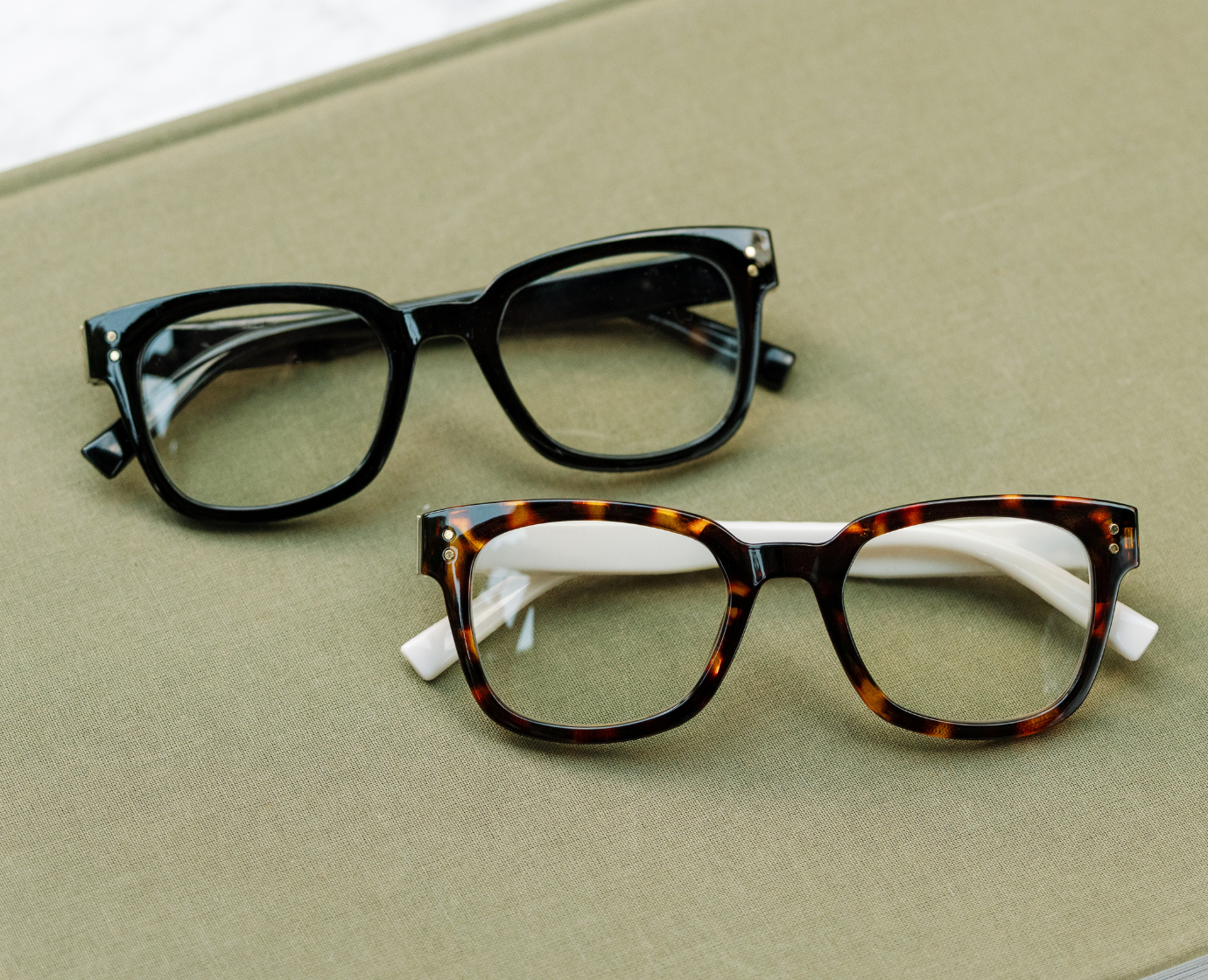 Peepers Aubrey blue light reading glasses in black, styled flat lay