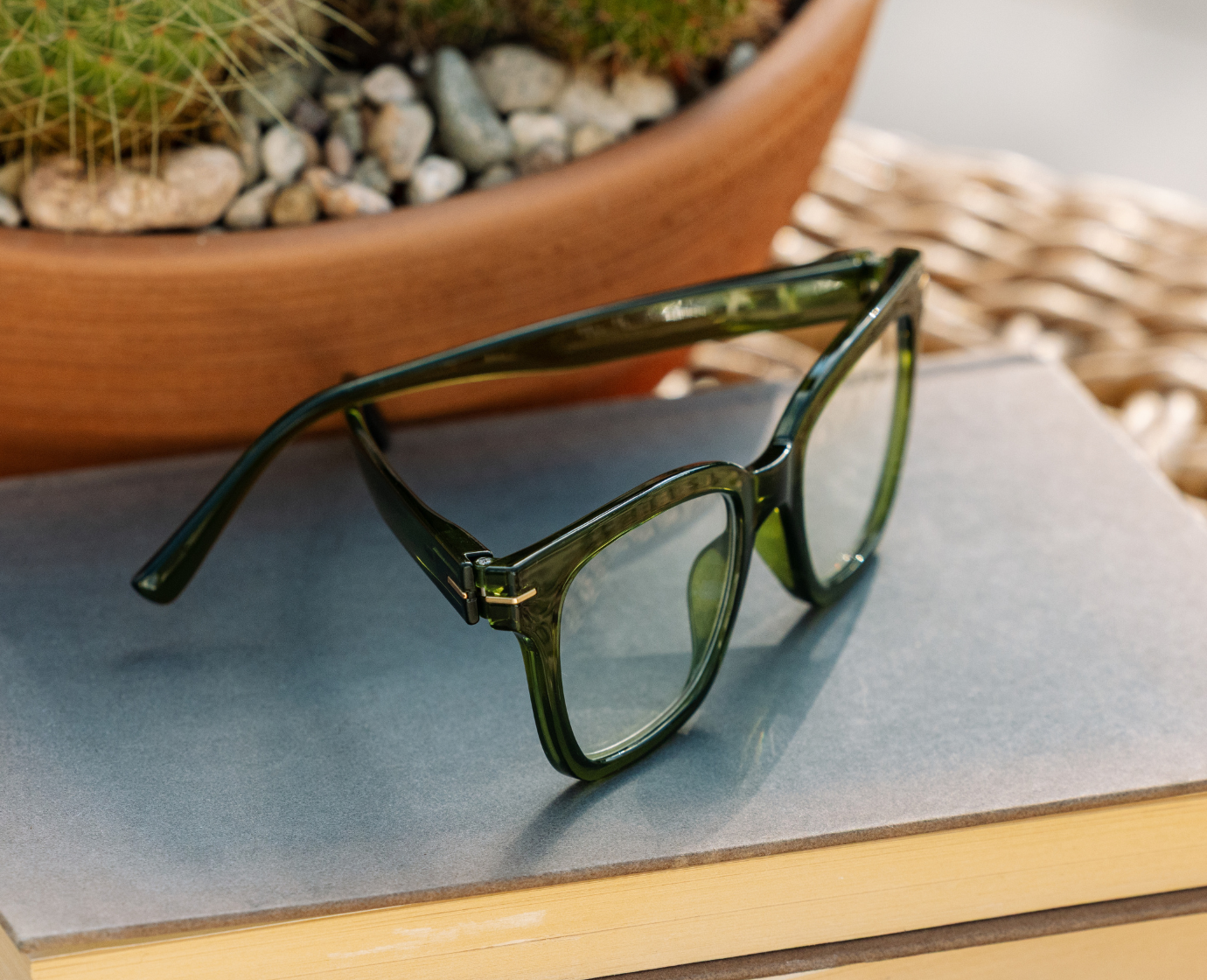 Peepers Buzzworthy reading glasses in green, styled flat lay