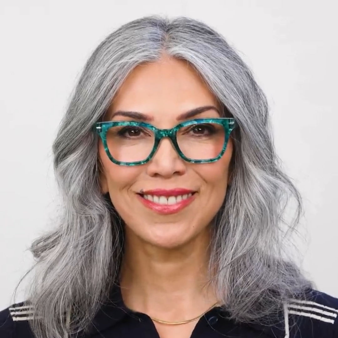 Woman wearing Peepers Buzzworthy blue light reading glasses in Turquoise Quartz