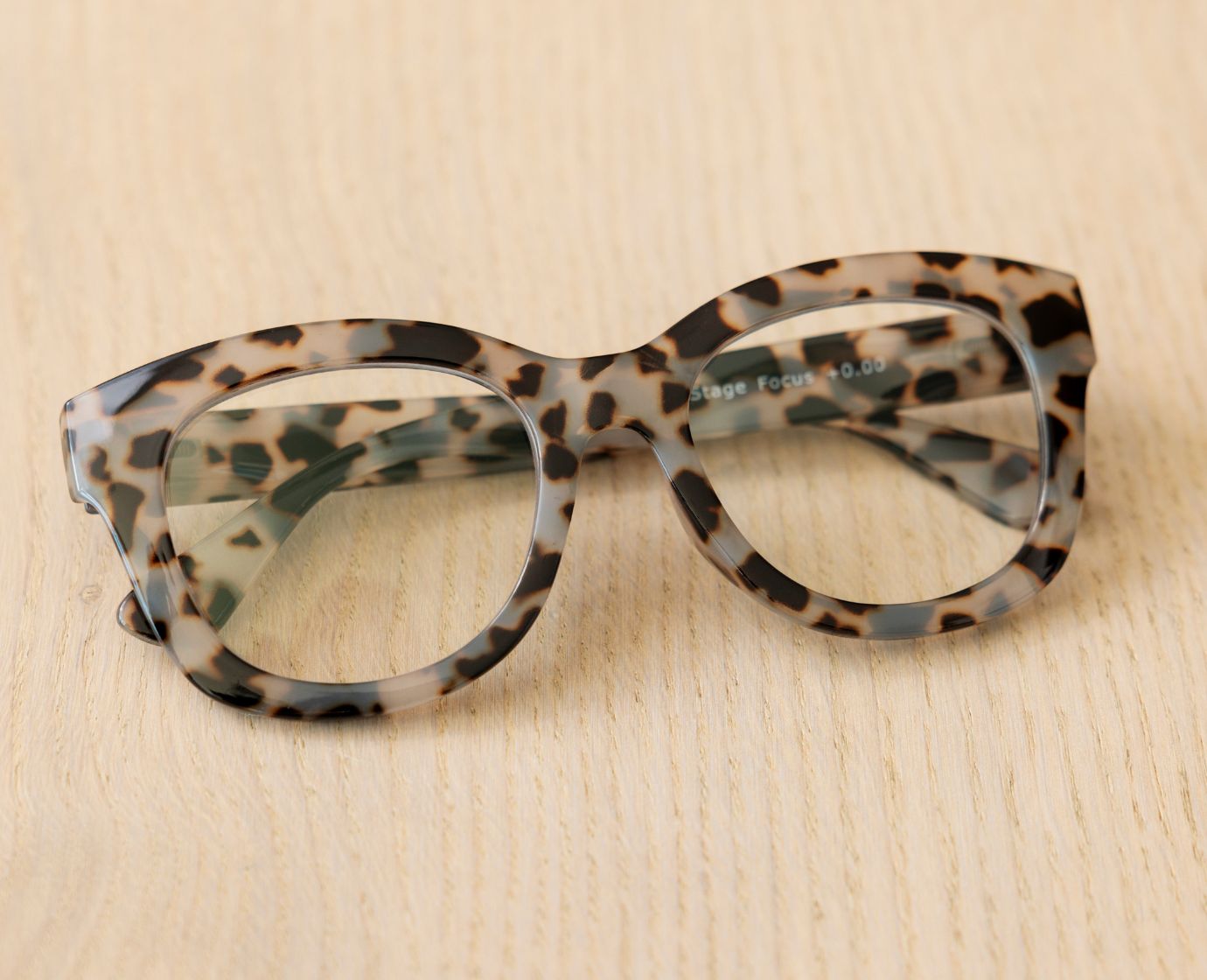 Peepers Center Stage reading glasses in Gray Tortoise, styled flat lay