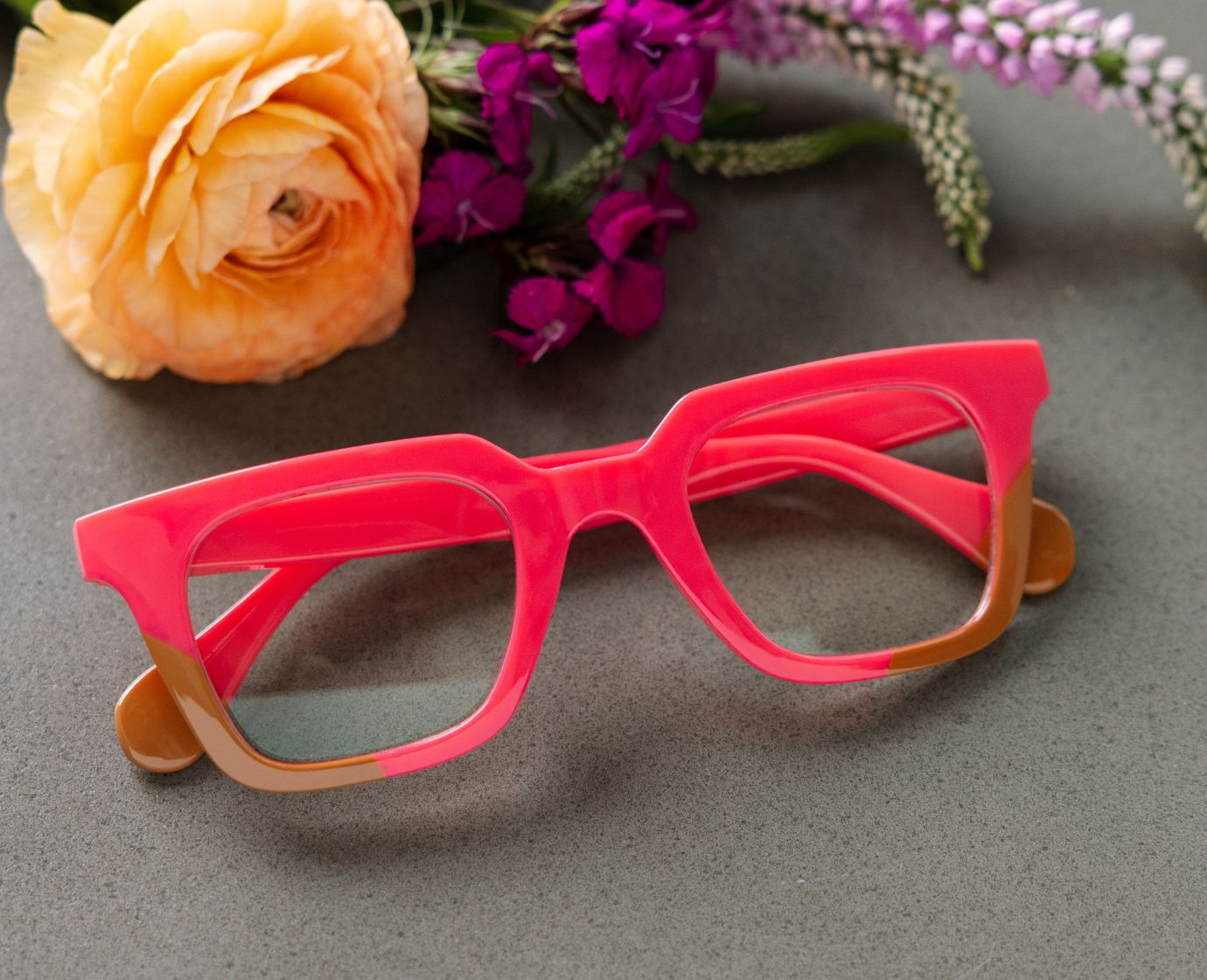 Peepers Page reading glasses in pink and tan, styled flat lay