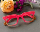 Peepers Page reading glasses in pink and tan, styled flat lay