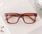 Peepers Spotlight reading glasses in rose, styled flat lay