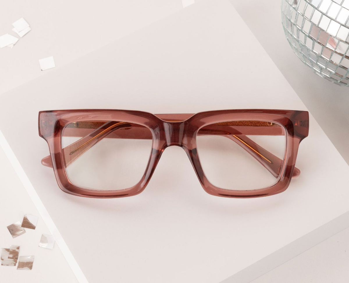Peepers Spotlight reading glasses in rose, styled flat lay