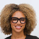 Woman wearing Peepers Take A Bow blue light reading glasses in navy