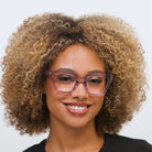 Woman wearing Peepers Take A Bow blue light reading glasses in purple
