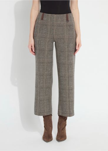 A model wearing a pair of cropped wide-leg trousers in a brown and beige plaid pattern, paired with a black top and brown suede ankle boots, against a plain white studio background.