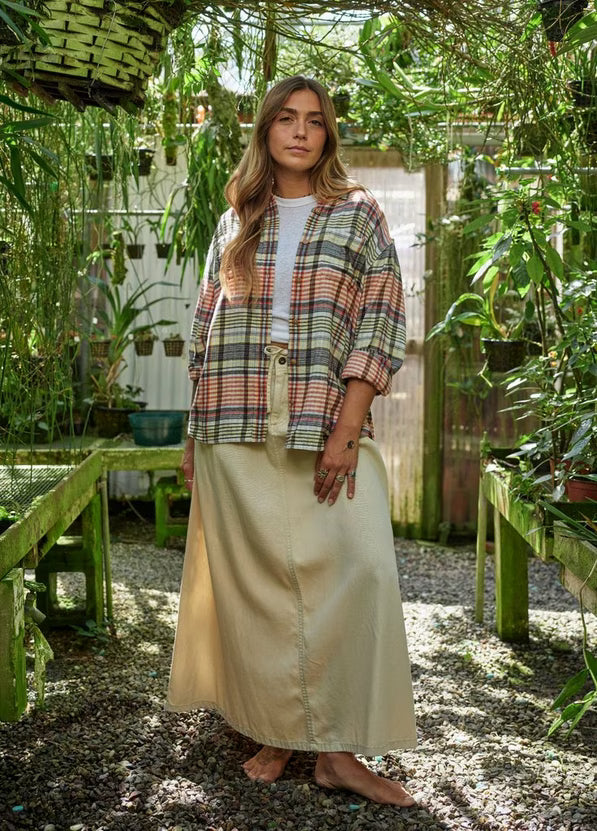 prAna Cabin Core Flannel Shirt in multi plaid sage, rust and cream, worn open over a white tee with a sage satin midi skirt in a greenhouse