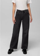 Front view of the prAna Carlsbad High Rise Wide Leg jeans in Black Sand, a faded washed black wide-leg jean worn with a white tee and black loafers