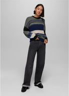 Model wearing the prAna Carlsbad High Rise Wide Leg jeans in Black Sand with a striped crewneck sweater and black loafers, cuffed at the hem