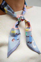 Equestrian print skinny scarf worn at the neck