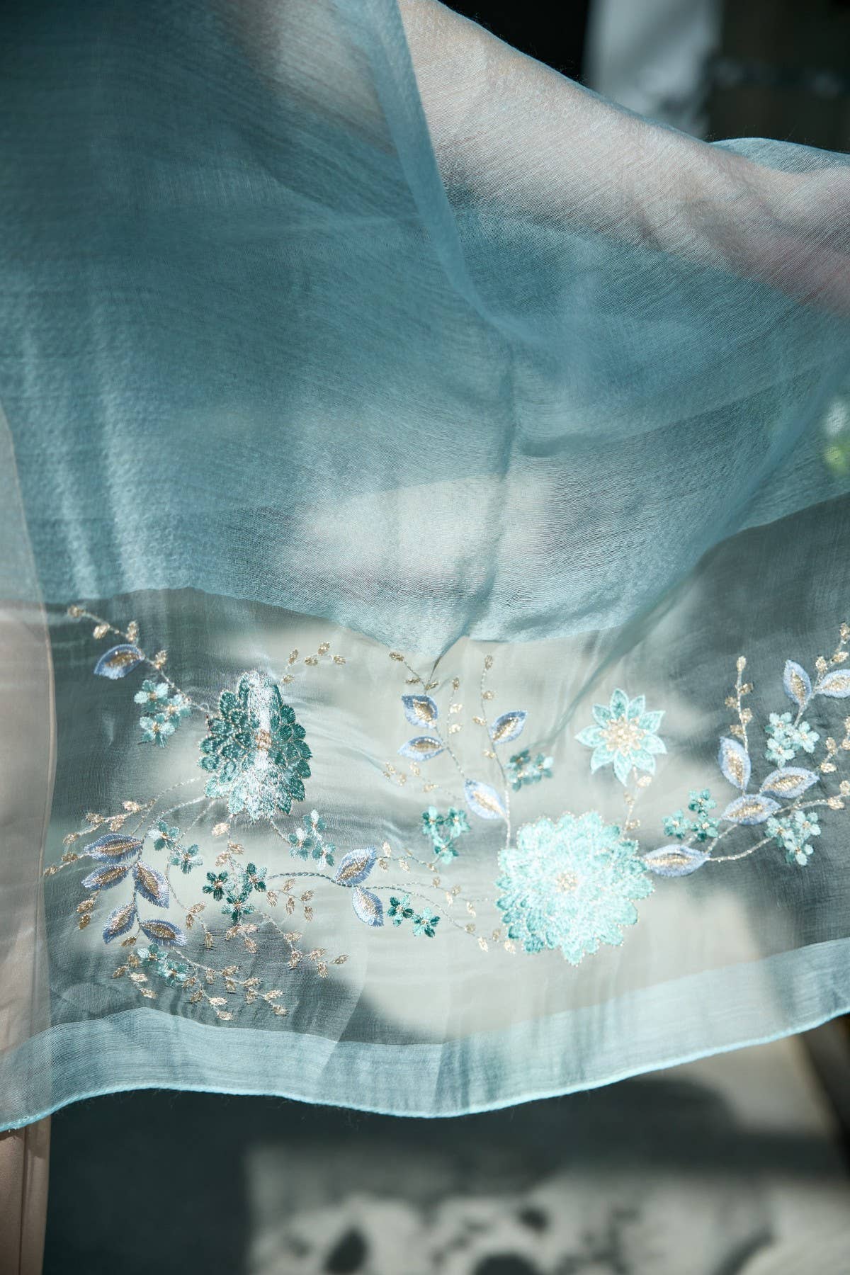 Aqua floral embroidered scarf styled as a wrap
