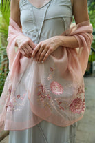 Blush pink floral embroidered scarf styled as a wrap