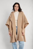 Light hooded oversized kimono with front pockets worn over jeans
