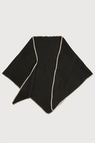 Black knitted triangle shawl laid flat with whipstitch edge