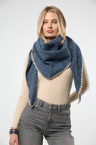 Denim blue knitted triangle shawl worn as a scarf