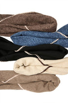 Knitted triangle shawls in taupe, denim, ivory, and black