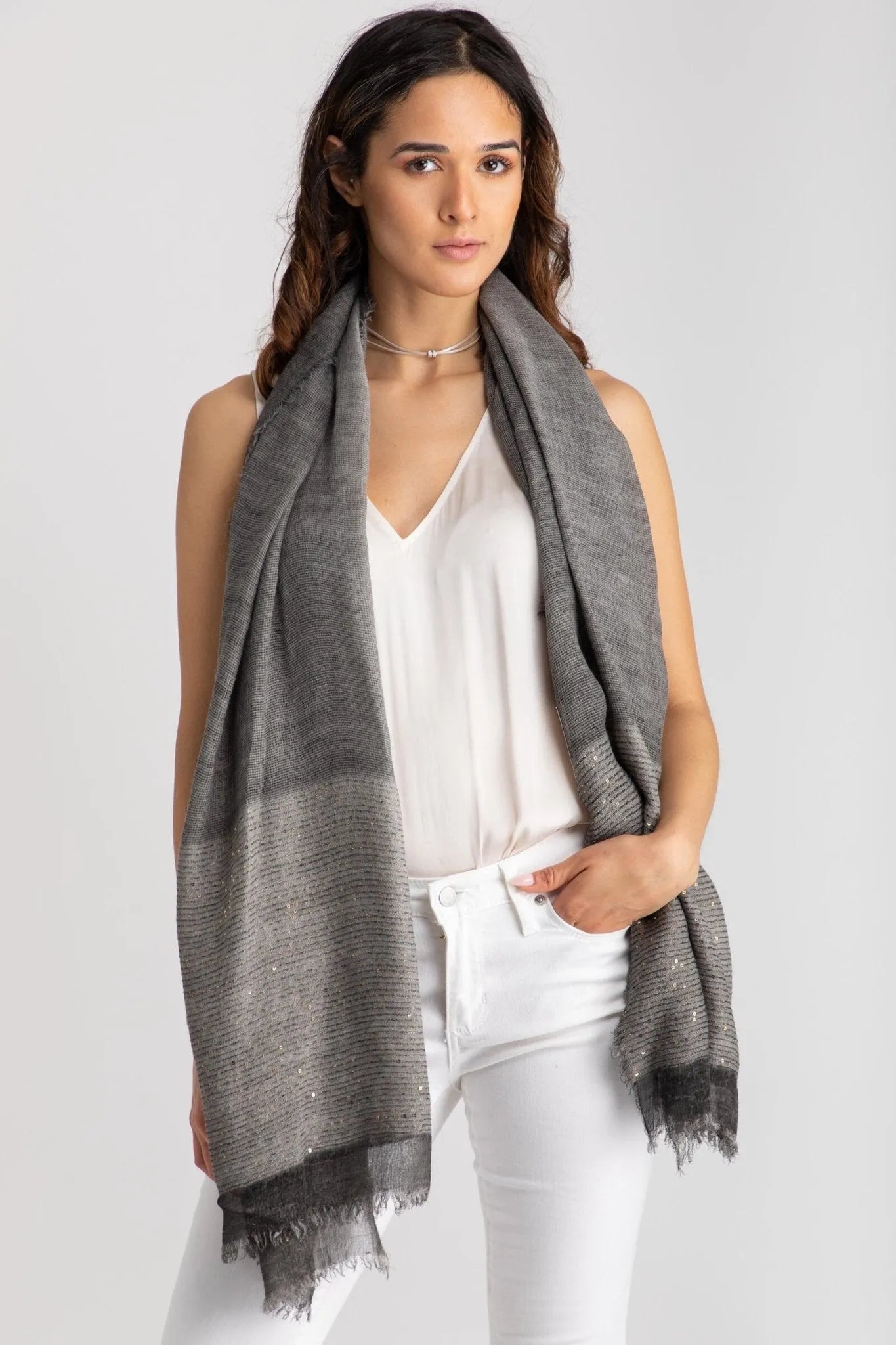 Dark grey shimmer scarf draped over a white top