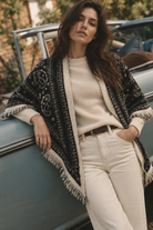 Paisley fringe triangle scarf styled as a shoulder wrap