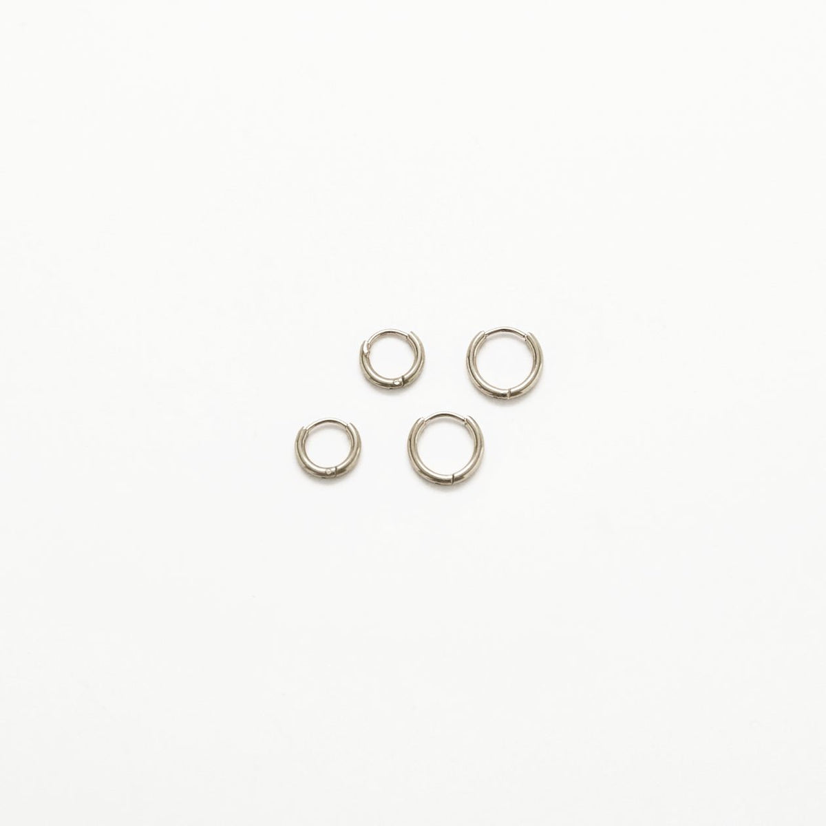 Silver mini huggie hoop earrings, two-pack, on a white background
