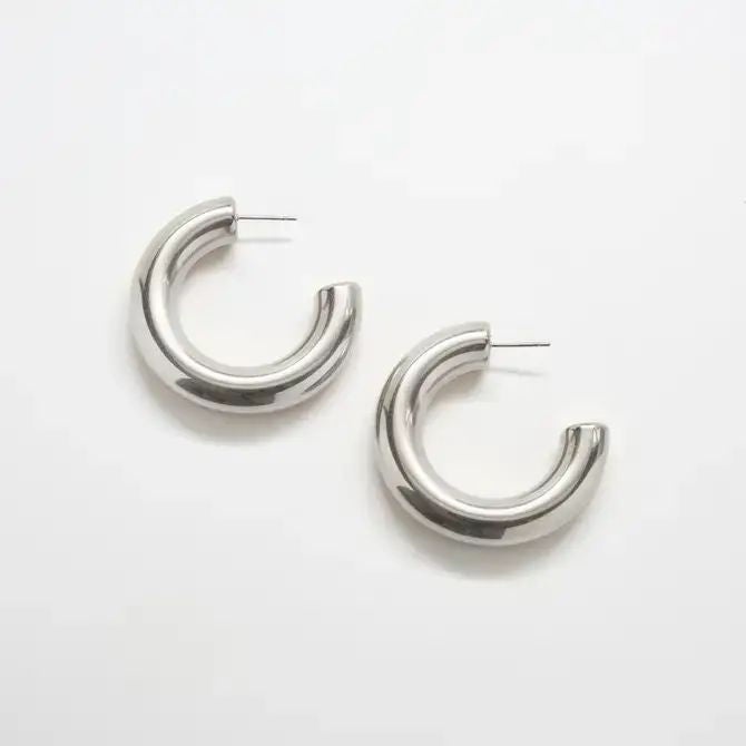 Silver medium chunky hoop earrings on a white background