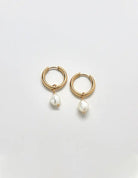 Single freshwater pearl huggie hoop earring on a white background