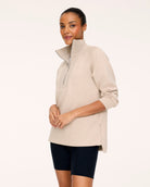 SPANX AirEssentials Brushed Half Zip Tunic, shown in Bone Heather, front view with funnel neck and tunic-length hem over bike shorts