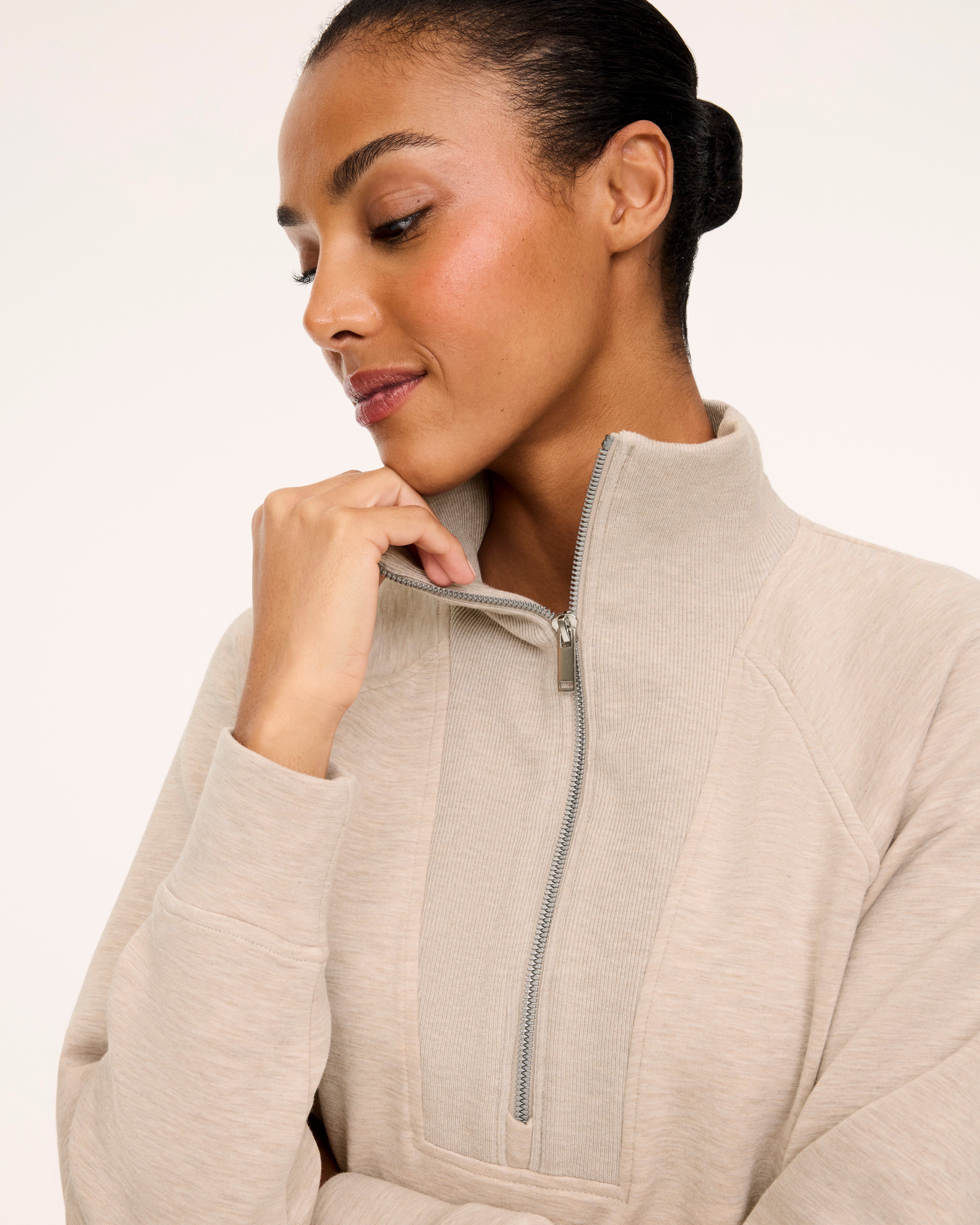 Close-up of the half-zip funnel neck on the SPANX AirEssentials Brushed Half Zip Tunic, shown in Bone Heather