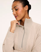 Close-up of the half-zip funnel neck on the SPANX AirEssentials Brushed Half Zip Tunic, shown in Bone Heather