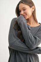 Woman wearing a gray sweater against a white background