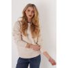 Model wearing the Trisha Tyler Textured Argyle Mockneck sweater in ivory with jeans