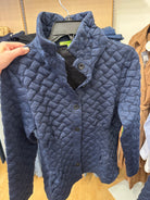 Trisha Tyler Quilted Button Down Jacket in Navy on a hanger, showing the basketweave quilted texture, stand collar, dark buttons and mesh lining