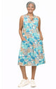 Tulip Clothing Women's Poppie Dress in Geo Candy, woman wearing a sleeveless midi dress with a teal, tan, and white geometric circle print and white sneakers, on a white background
