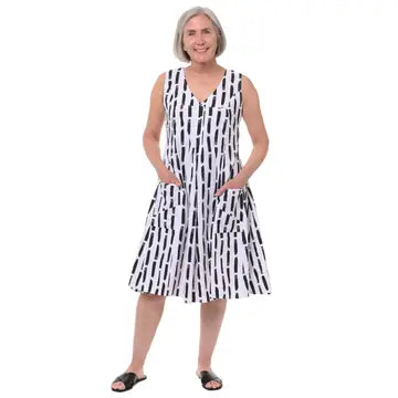 Tulip Clothing Women's Poppie Dress in White Black Canvas, woman modeling a sleeveless V-neck midi dress with a black and white vertical striped pattern and side pockets, set against a plain white background