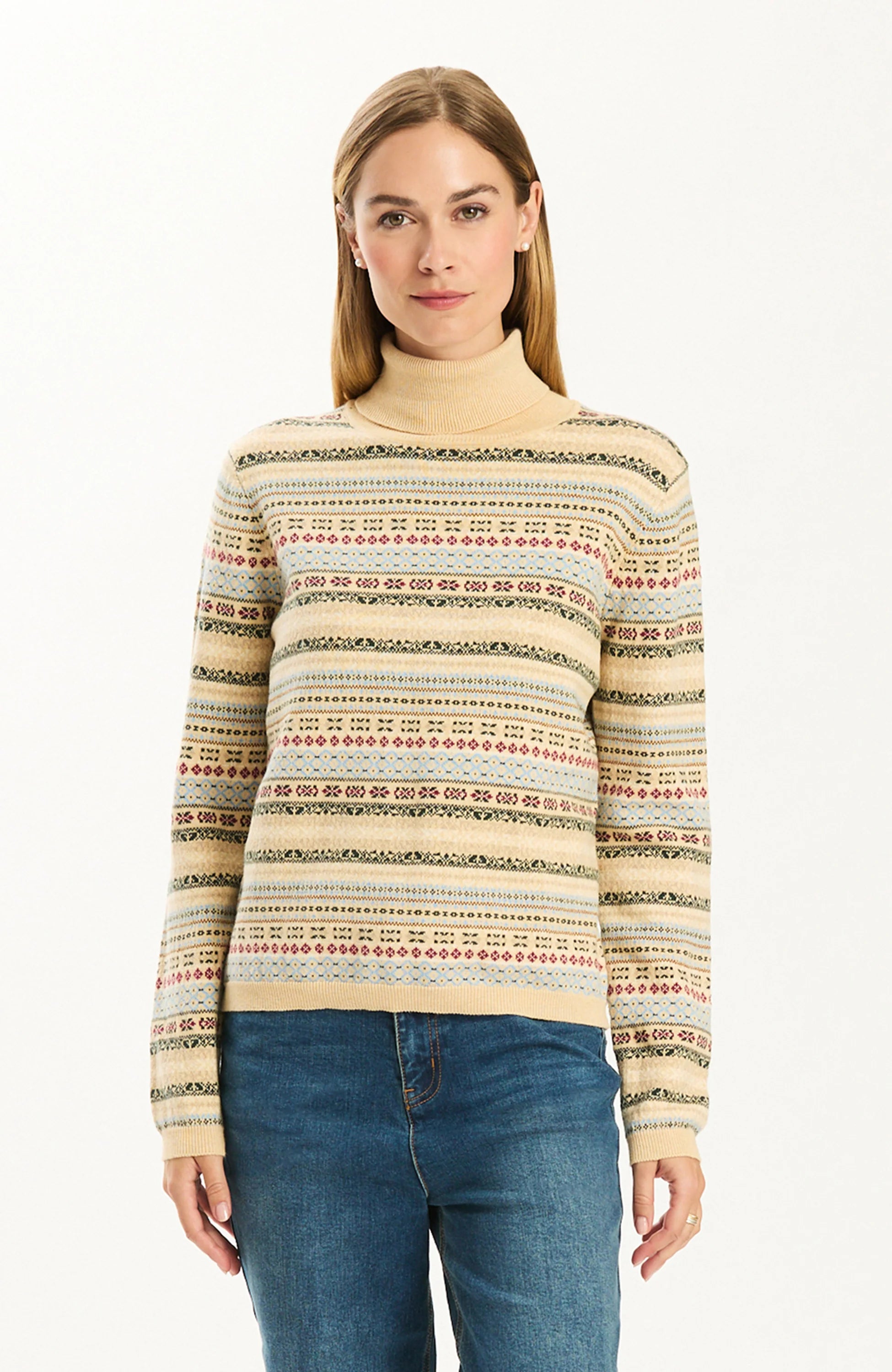 Woman wearing the Tyler Boe Jen Fair Isle Turtleneck Sweater in a cream multicolor Fair Isle pattern with blue jeans