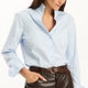 Tyler Böe Natalie Sateen Shirt in light blue, front view, tucked into brown faux-leather pants