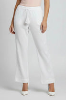 White wide-leg pants with embroidered floral details down the sides and a drawstring waist, shown on a model against a light gray background.