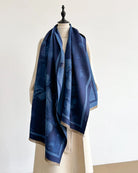 Winding River Opening Flower Reversible Wrap/Scarf in navy and blue tonal floral print with fringed ends, draped on a dress form