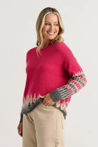 Side view of the Zaket & Plover Jacquard Sweater in Fuchsia showing the relaxed fit and jacquard sleeves, styled with beige trousers